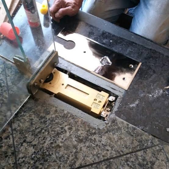 Instalação de mola em porta de vidro durante manutenção de porta Blindex